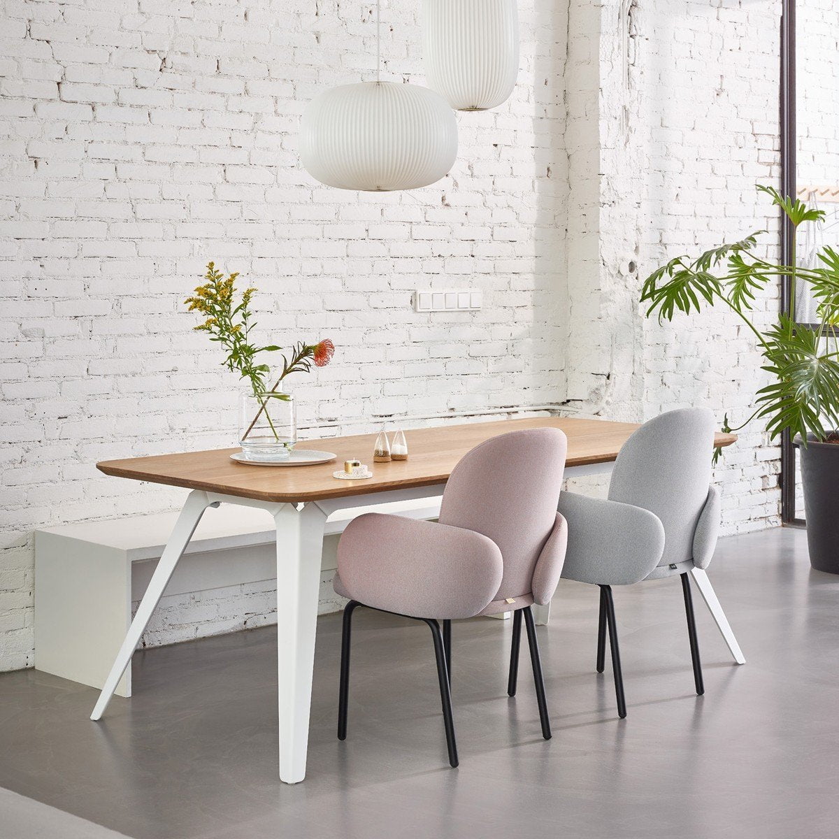 A dining table and chairs with the Puik Boeien Salt & Pepper Set 2 Pak in a room with white walls.